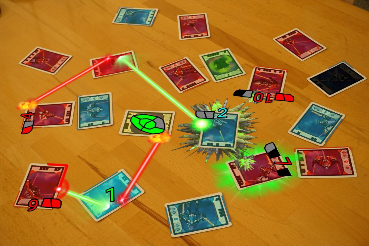 A photo of a table scattered with Light Speed cards with graphics of laser beams and augmented reality explosions and a violent green explosion.