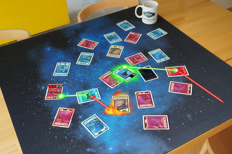 A photo of a table scattered with Light Speed cards with graphics of laser beams and explosions in augmented reality.